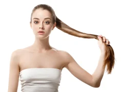 Une femme qui a les cheveux longs qu'elle tient dans sa main