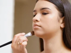 Une femme qui applique un fond de teint au pinceau