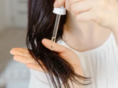 Une femme qui applique de l'huile de ricin sur ses cheveux