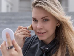 Une femme qui applique de l'highlighter maquillage