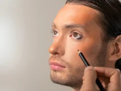 Un homme qui se fait appliquer du khôl noir sous les yeux